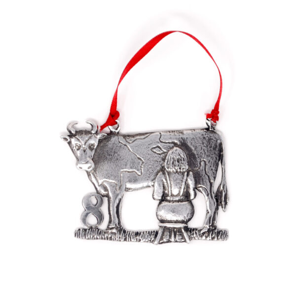picture of decoration sculpted maid milking a cow decoration hanging on a red ribbon