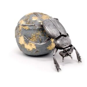 pewter dung beetle pushing a concrete ball with its back legs. The ball has straw in it and some 24ct gold leaf on the surface