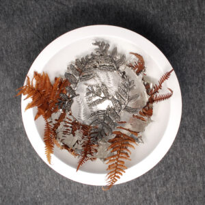 Detail of Hidden Ferns showing preserved fern fronds, sculpted pewter botanicals and intricate pierced fern cut-outs by Fleur Grenier.