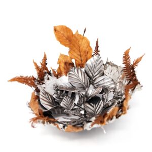 Hidden leaves and ferns sculpture resting on a white top