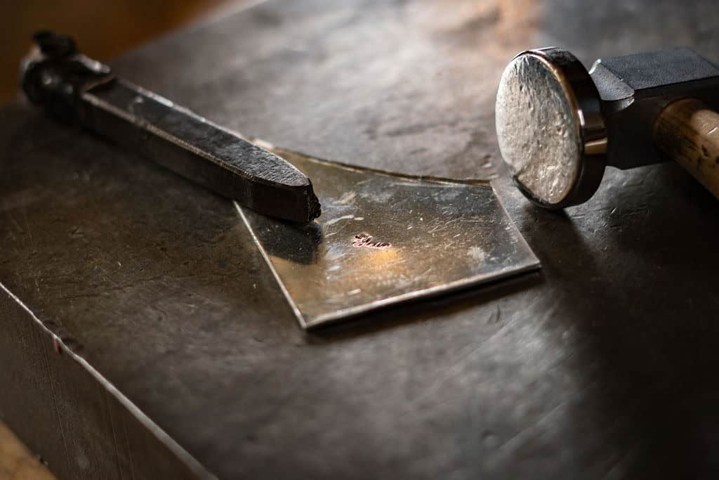 pewter touchmark fleurs signature stamp with a hammer next to it